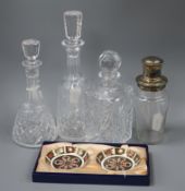 A plated and glass cocktail shaker, three cut glass decanters and a pair of Royal Crown Derby