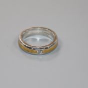A modern platinum and yellow metal, gypsy set solitaire diamond ring, size L.