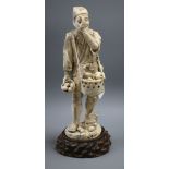 A Meiji carved ivory figure of a man inspecting bird eggs, a sectional carving