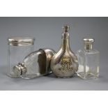 A silver perfume flask with monogram, two silver-mounted toilet bottles and a silver-mounted glass