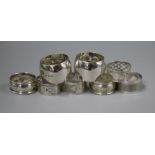 Three pairs of silver napkin rings and a plated pair of napkin rings.