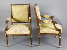 A pair of Louis XVI style parcel gilt carved walnut fauteuil, with upholstered backs, arms and