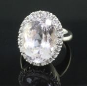 An 18ct white gold, kunzite and diamond oval cluster dress ring, size L.