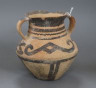 A pottery two-handled vessel, possibly pre-Columbian, with black painted linear decoration and strap