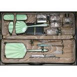 A 1930's Art Deco travelling toilet case containing eight silver mounted items by Walker & Hall, and