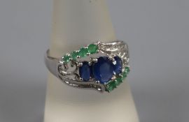 A modern 14ct white gold, sapphire, emerald and diamond cluster dress ring, size Q.