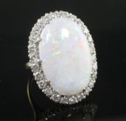 An 18ct gold, white opal and diamond oval cluster ring, the opal measuring 20mm by 13mm, size K.