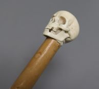 A cane mounted with ivory carving of a skull length 93cm