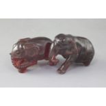 Two natural cherry amber figures of elephants, late 19th/early 20th century, each naturalistically