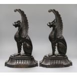 A pair of cast iron griffins height 38cm