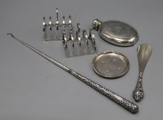 A pair of silver toastracks, a Victorian silver hip flask, small dish, button hook and shoe horn.