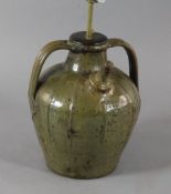 A French medieval green glazed jar, of squat globular form with twin strap handle, fitted for