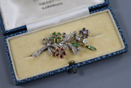 A white and yellow gold multi-gem floral spray brooch, set with emeralds, rubies, sapphires and