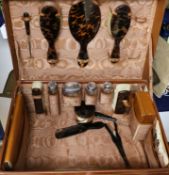 A leather travelling toilet case containing four late Victorian silver mounted jars and thirteen