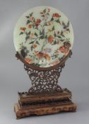 A Chinese hardstone circular plaque and hongmu stand, early 20th century, the plaque decorated