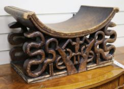 A West African, possibly Ghanaian, tribal stool, having curved seat over a pair of supports, each