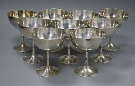 A set of nine near matching silver champagne coupes, with beaded ring-turned stems and foot rims,