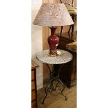 A wrought iron circular tripod table and a lamp W.49.5cm
