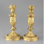 A pair of mid 19th century French ormolu candlesticks, each modelled with three bacchanalian figures