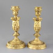 A pair of mid 19th century French ormolu candlesticks, each modelled with three bacchanalian figures