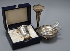 A cased silver christening mug, a silver bonbon basket, a silver posy vase and three silver spoons.