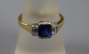 A modern 18ct gold, three stone sapphire and diamond dress ring, size N.