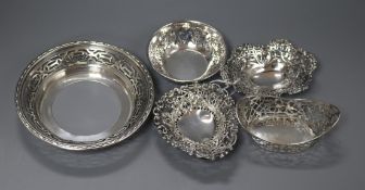 Four assorted pierced silver bonbon dishes and one other pierced silver dish.