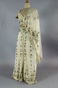 A floor length cream net evening dress, heavily embroidered with silver and gold coloured thread,