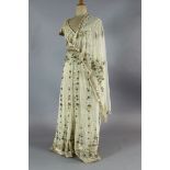 A floor length cream net evening dress, heavily embroidered with silver and gold coloured thread,