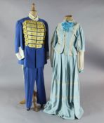 Rigoletto: A rail with a pale blue skirt and jacket, a quantity of royal blue gold braided jackets