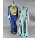 Rigoletto: A rail with a pale blue skirt and jacket, a quantity of royal blue gold braided jackets