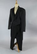 A collection of twenty one black tail coats and twenty one trousers, in mixed sizes