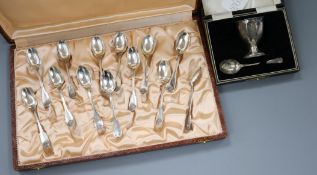 A cased set of twelve French white metal coffee spoons and a cased silver egg cup & spoon.