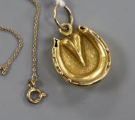 An 18ct gold "horseshoe" locket, on an 8ct gold fine link chain, locket 21mm.