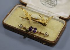 An Edwardian 15ct gold and seed pearl twin swallow brooch and a yellow metal gem set bar brooch.