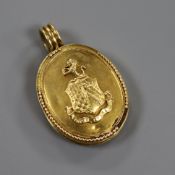 A yellow metal oval enclosed locket, late 19th/early 20th century, one side applied with a coat of