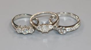 Two 18ct white gold and diamond rings and a platinum and three stone diamond ring.