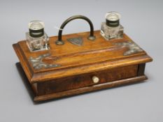 An oak desk stand with silver-plated mounts, fitted two plain inkwells, pen tray and drawer with