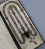 An early 20th French amethyst bead necklace, with white metal cross pendant drop, approx. 90cm.