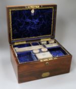 A Victorian travelling rosewood toilet box with seven silver mounted jars, London, 1871 and one