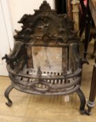 A Gothic style cast iron fire grate, the scroll back decorated with a Bagot goat jumping a fence,