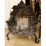 A Gothic style cast iron fire grate, the scroll back decorated with a Bagot goat jumping a fence,