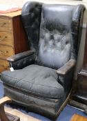 A leather button back wing armchair