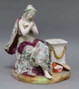 A Meissen-style figure seated beside a pedestal height 29cm