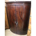 A Regency mahogany bowfront corner cupboard W.99cm