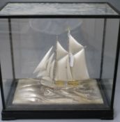 A parcel gilt sterling silver model of a sailing ship, on a stepped ebonised base, in a glazed case,