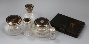 Four silver and tortoiseshell mounted glass toilet jars, a silver mounted scent bottle and a