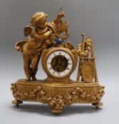 A spelter mantel clock mounted with a cherub, revolving pendulum height 37cm