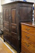 An early 18th century oak wardrobe / cupboard enclosed by fielded panels W.136cm