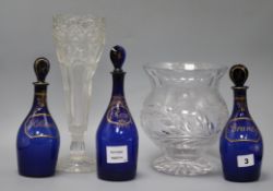 Three Bristol blue glass decanters and stoppers, Brandy, Rum and Hollands, and two vases tallest